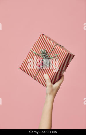 In der Nähe der weiblichen Hand Weihnachten bis über rosa Hintergrund vorhanden Stockfoto