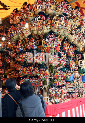 Tokio, Japan. 8. November, 2019. Bezaubernd gestalteten Bambus Rechen für gutes Glück werden an Ständen auf der Ansatz für ein Shinto Schrein während einer pulsierenden Messe gesäumt auf Tokyos Stadtteil Asakusa am Freitag verkauft, 8. November 2019. Jedes Jahr im November Tausende von Japanischen besuchen den Schrein für gute Geschäfte im kommenden Jahr und kaufen viel Glück Rechen glaubte, das Glück zu Familien zu bringen, um zu beten. Credit: Natsuki Sakai/LBA/Alamy leben Nachrichten Stockfoto