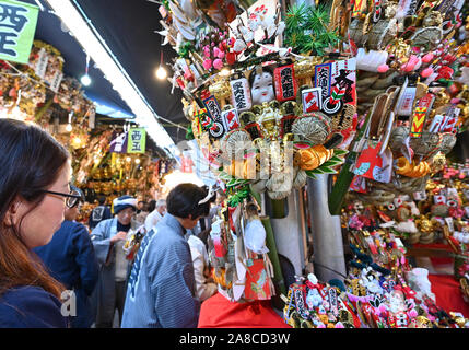 Tokio, Japan. 8. November, 2019. Bezaubernd gestalteten Bambus Rechen für gutes Glück werden an Ständen auf der Ansatz für ein Shinto Schrein während einer pulsierenden Messe gesäumt auf Tokyos Stadtteil Asakusa am Freitag verkauft, 8. November 2019. Jedes Jahr im November Tausende von Japanischen besuchen den Schrein für gute Geschäfte im kommenden Jahr und kaufen viel Glück Rechen glaubte, das Glück zu Familien zu bringen, um zu beten. Credit: Natsuki Sakai/LBA/Alamy leben Nachrichten Stockfoto