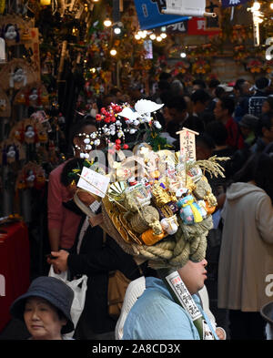 Tokio, Japan. 8. November, 2019. Bezaubernd gestalteten Bambus Rechen für gutes Glück werden an Ständen auf der Ansatz für ein Shinto Schrein während einer pulsierenden Messe gesäumt auf Tokyos Stadtteil Asakusa am Freitag verkauft, 8. November 2019. Jedes Jahr im November Tausende von Japanischen besuchen den Schrein für gute Geschäfte im kommenden Jahr und kaufen viel Glück Rechen glaubte, das Glück zu Familien zu bringen, um zu beten. Credit: Natsuki Sakai/LBA/Alamy leben Nachrichten Stockfoto