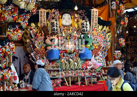 Tokio, Japan. 8. November, 2019. Bezaubernd gestalteten Bambus Rechen für gutes Glück werden an Ständen auf der Ansatz für ein Shinto Schrein während einer pulsierenden Messe gesäumt auf Tokyos Stadtteil Asakusa am Freitag verkauft, 8. November 2019. Jedes Jahr im November Tausende von Japanischen besuchen den Schrein für gute Geschäfte im kommenden Jahr und kaufen viel Glück Rechen glaubte, das Glück zu Familien zu bringen, um zu beten. Credit: Natsuki Sakai/LBA/Alamy leben Nachrichten Stockfoto