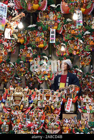 Tokio, Japan. 8. November, 2019. Bezaubernd gestalteten Bambus Rechen für gutes Glück werden an Ständen auf der Ansatz für ein Shinto Schrein während einer pulsierenden Messe gesäumt auf Tokyos Stadtteil Asakusa am Freitag verkauft, 8. November 2019. Jedes Jahr im November Tausende von Japanischen besuchen den Schrein für gute Geschäfte im kommenden Jahr und kaufen viel Glück Rechen glaubte, das Glück zu Familien zu bringen, um zu beten. Credit: Natsuki Sakai/LBA/Alamy leben Nachrichten Stockfoto