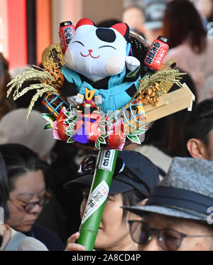 Tokio, Japan. 8. November, 2019. Bezaubernd gestalteten Bambus Rechen für gutes Glück werden an Ständen auf der Ansatz für ein Shinto Schrein während einer pulsierenden Messe gesäumt auf Tokyos Stadtteil Asakusa am Freitag verkauft, 8. November 2019. Jedes Jahr im November Tausende von Japanischen besuchen den Schrein für gute Geschäfte im kommenden Jahr und kaufen viel Glück Rechen glaubte, das Glück zu Familien zu bringen, um zu beten. Credit: Natsuki Sakai/LBA/Alamy leben Nachrichten Stockfoto