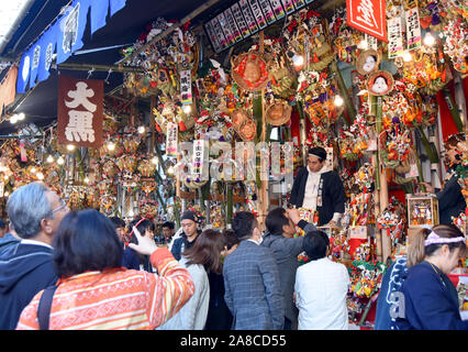 Tokio, Japan. 8. November, 2019. Bezaubernd gestalteten Bambus Rechen für gutes Glück werden an Ständen auf der Ansatz für ein Shinto Schrein während einer pulsierenden Messe gesäumt auf Tokyos Stadtteil Asakusa am Freitag verkauft, 8. November 2019. Jedes Jahr im November Tausende von Japanischen besuchen den Schrein für gute Geschäfte im kommenden Jahr und kaufen viel Glück Rechen glaubte, das Glück zu Familien zu bringen, um zu beten. Credit: Natsuki Sakai/LBA/Alamy leben Nachrichten Stockfoto
