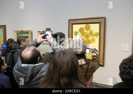 Besucher können Sie über ihre Smartphones Bilder von Vincent van Gogh's Öl Malerei unflowers', in der National Gallery in London, Vereinigtes Königreich, Stockfoto