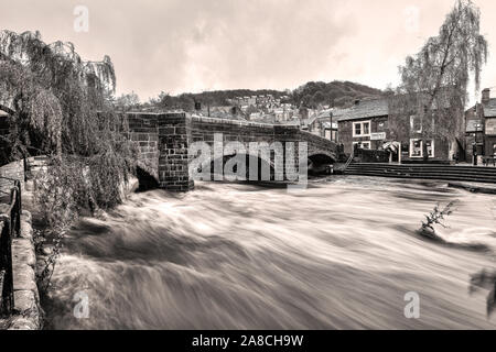 Hebden Wasser in Überflutung und Alten Packesel Brücke, Hebden Bridge, Pennines, Calderdale, Yorkshire Stockfoto