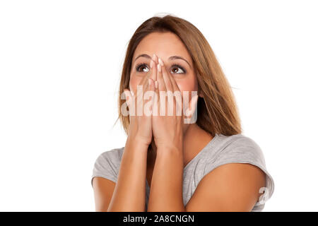 Glückliche junge Frau deckt ihr Gesicht mit den Händen Stockfoto