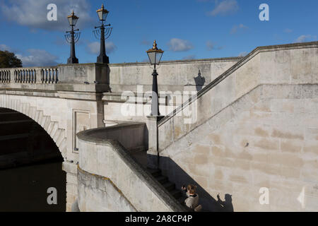 Vom Südufer der Themse ist die Architektur der Kingston Bridge, wo ein Fußgänger seine Schritte klettert gesehen, am 7. November 2019 in Kingston, London, England. Eine Kreuzung hat am Kingston existiert seit der Antike und dieser Version von Kingston Bridge von Herbert für £ 26.800 konstruiert wurde und durch die Herzogin von Clarence (die zukünftige Königin Adelaide) am 17. Juli 1828 eröffnet. Von Portland aus Stein gebaut, es besteht aus fünf elliptische Bögen. Stockfoto