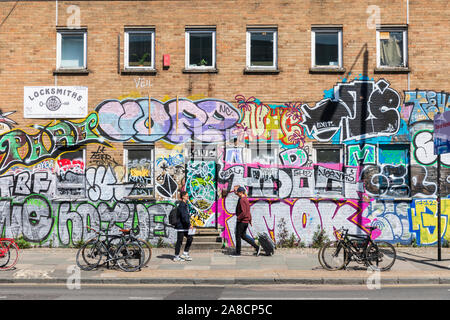 Fußgänger vorbei Street Art in Shoreditch, East London, England, UK. Stockfoto