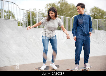 Zwei weibliche Freunde Reiten auf Skateboards in urbanen Skate Park Stockfoto