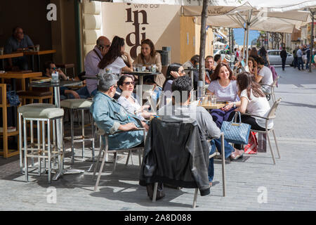 Heraklion, Kreta, Griechenland. Kunden entspannen in einem beliebten Stadtzentrum Straßencafé. Stockfoto