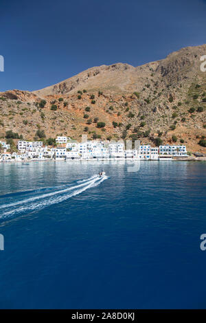 Loutro, Chania, Kreta, Griechenland. Kleines Boot, das über den Hafen raste. Stockfoto