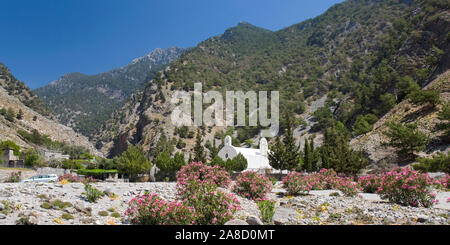 Agia Roumeli, Samaria Nationalpark, Chania, Kreta, Griechenland. Kleine weiße Kirche am Eingang zur Samaria-Schlucht, wilder Oleander im Vordergrund. Stockfoto