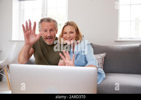 Senior Paar sitzt auf einem Sofa zu Hause Video mit Laptop zusammen Stockfoto