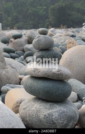 Eine Pyramide aus Kieselsteinen entlang der Ufer des Flusses Dawki. Stockfoto