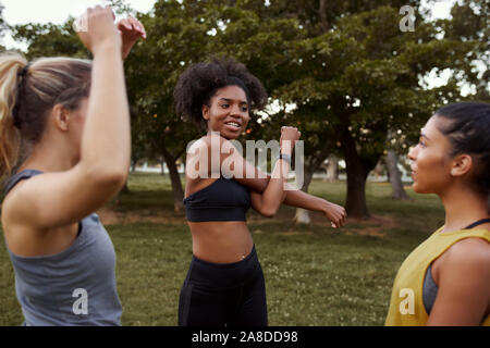 Gruppe von Fit aktiv multiethnischen weibliche Freunde Aufwärmen vor dem Training im Park Stockfoto