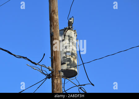 Nahaufnahme des generischen alten rostigen elektrischer Transformator auf Pole isoliert mit der Alterung Stromnetz zu bedeuten Stockfoto