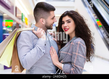 Junges Paar kuscheln nach dem Shopping in der Mall Stockfoto