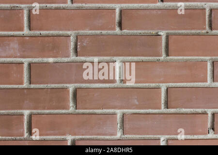 Braun rötlich dunklen Backstein, Textur Hintergrund. Baumaterial für die Außenwände von Gebäuden. Mauerwerk Schach eine Reihe von Backsteinen mit Stockfoto