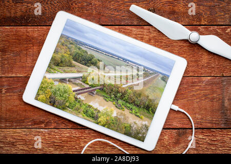 Autobahnbrücke und Bock von verlassenen Bahnhof über einen Fluss - die Überprüfung der Ein luftbild auf einem digitalen Tablet Stockfoto