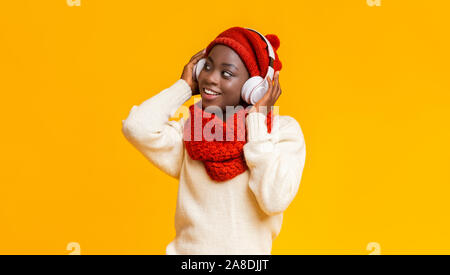 Aufgeregt afro Mädchen mit Wireless Headset zur Seite suchen Stockfoto