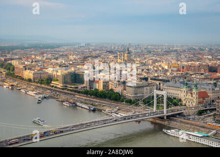 Ein Panoramablick vom Gellert Hügel über die Stadt Budapest, wunderschön von der Sonne beleuchtet, Donau mit Elisabeth Brücke und Kreuzfahrtschiffe. Stockfoto