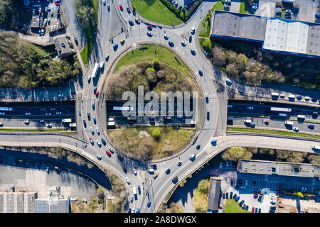 Overhead, Luftbilder von einem Kreisverkehr bei rush hour, besetzt mit Verkehr pendeln zu und von der Arbeit, Schulen, Kindertagesstätten und anderen Leben braucht Stockfoto