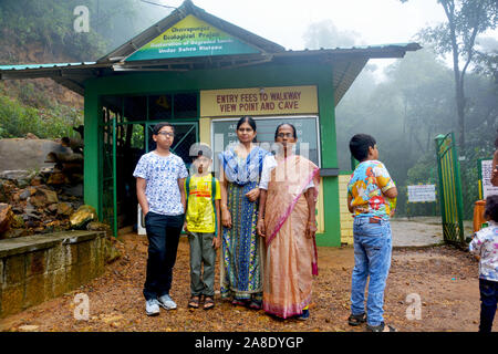 Eine indische Familie, bestehend aus Mutter, Tochter und zwei Jungen vor dem Ticketschalter von Cherrapunjee ökologisches Projekt posing Stockfoto