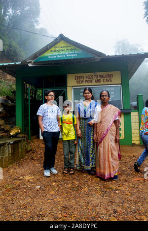 Eine indische Familie, bestehend aus Mutter, Tochter und zwei Jungen vor dem Ticketschalter von Cherrapunjee ökologisches Projekt posing Stockfoto