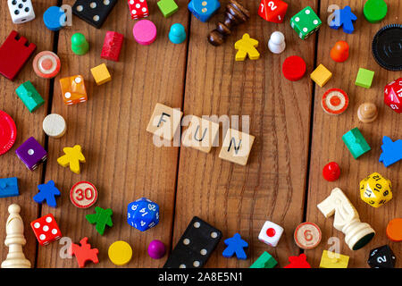 "Fun" in Holz- Brief Fliesen geschrieben. Durch würfeln, Karten umgeben, und andere Spielsteine auf einem hölzernen Hintergrund Stockfoto