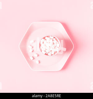 Tasse heiße Schokolade und Marshmallows auf einem Rosa pastell Hintergrund. Flach, Ansicht von oben. Stockfoto