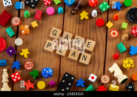 "Game Plan" in Holz- Brief Fliesen geschrieben. Durch würfeln, Karten umgeben, und andere Spielsteine auf einem hölzernen Hintergrund Stockfoto