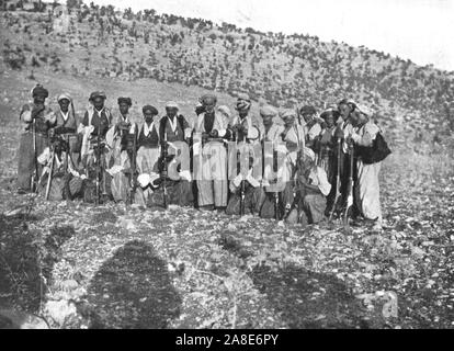 "Ahmed Agha', c 1906-1913, (1915). Kurdische Männer mit Gewehren und bullet Gürtel, Shirwan, (Türkei). "Ein wenig weiter trafen wir uns Ahmed Agha und 50 bewaffnete Banditen. Die Aga war ein großer, stattlicher Mann, mit einem pathetisch und schikaniert, Ausdruck. Er traurig wies auf die rauchenden Ruinen jenseits des Wassers, und zeigte uns die Verdammten ausgebrannten Bewohner, Sammeln von Holz und Steinen, mit denen neue Häuser zu bauen... Als ich sah diese Verwüstung, fing ich an, zu der die Vorteile der zentralen Regierung in feudalen Zeiten' Denken. Von "Kalifen" Letzte Erbe, eine kurze Geschichte des türkischen Reichs" Stockfoto