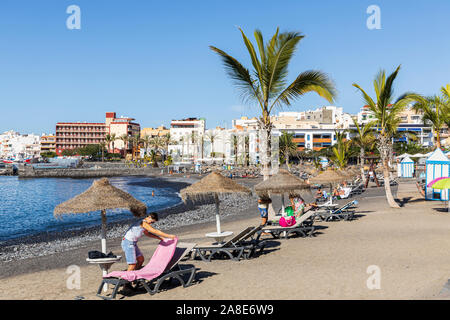 Touristen und Palmen am Strand von Playa San Juan, Teneriffa, Kanarische Inseln, Spanien Stockfoto