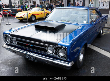 Drei Viertel Vorderansicht einer Blau, 1967, Plymouth GTX, auf Anzeige in der Regents Street Motor Show 2019 Stockfoto