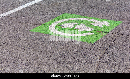 Eine grüne und weiße Symbol zeigt an, dass ein Punkt in einem Parkplatz ist nur für Elektrofahrzeuge, die in Rechnung gestellt werden kann. Stockfoto