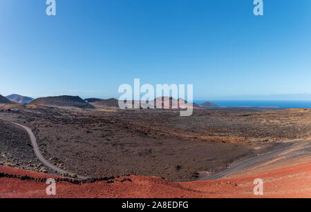 Farbenprächtige Vulkanlandschaft im Nationalpark Timanfaya, Montanas del Fuego, auf Lanzarote, Kanarische Inseln gegen blauen Himmel Stockfoto