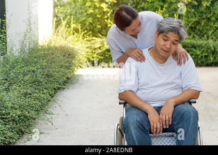 Der Patient ist Depression Sitzen im Rollstuhl durch den Verlust eines geliebten Menschen und einige körperliche Krankheiten und eine Nebenwirkung der medizinischen Behandlung verursacht Stockfoto