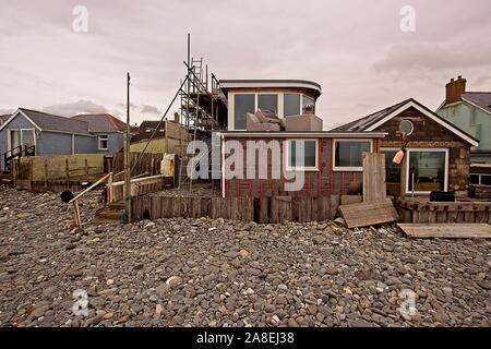 Portfolio von einzigartigen Eigenschaften mit Blick nach hinten über einem Kieselstrand. Stockfoto