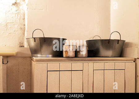 Innenraum der Alten Taverne Restaurant mit alten cremefarbenen Holzmöbeln und Metall Küchenutensilien. Vintage Style. Stockfoto
