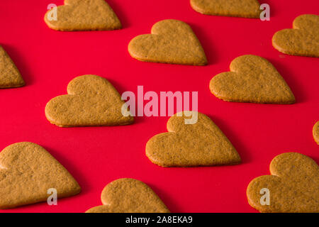 Herzförmige Plätzchen Muster auf rotem Hintergrund isoliert. Valentinstag und Muttertag Konzept. Stockfoto