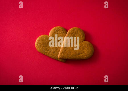 Herzförmige Plätzchen auf roten Hintergrund isoliert. Valentinstag und Muttertag Konzept. Stockfoto