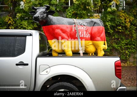 08 November 2019, Bayern, Würzburg: In einem Protest der Bauern vor dem Kongress der lokalen politischen Vereinigung der CDU und CSU, ein schwarz-rot-goldenen Kuh mit der Aufschrift "die faire Milch" (Die faire Milch) auf der Ladefläche eines Pick-up-Truck gesehen werden. Foto: Nicolas Armer/dpa Stockfoto
