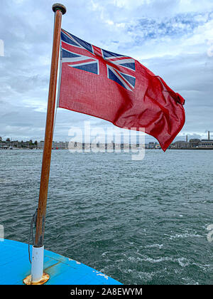 Red Ensign Fliegen in die Meeresbrise und Southampton Docks im Hintergrund. Stockfoto