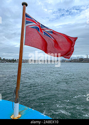 Red Ensign Fliegen in die Meeresbrise und Southampton Docks im Hintergrund. Stockfoto