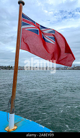 Red Ensign Fliegen in die Meeresbrise und Southampton Docks im Hintergrund. Stockfoto