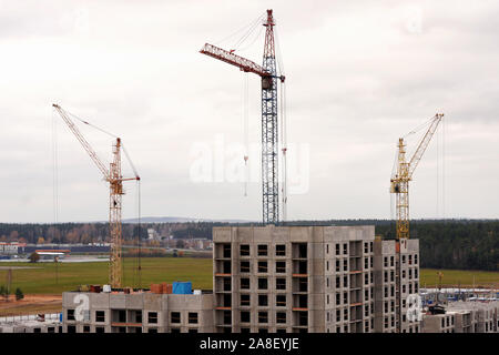 Bau eines neuen Wohnviertel. Krane über mehrstöckige Gebäude im Bau Stockfoto
