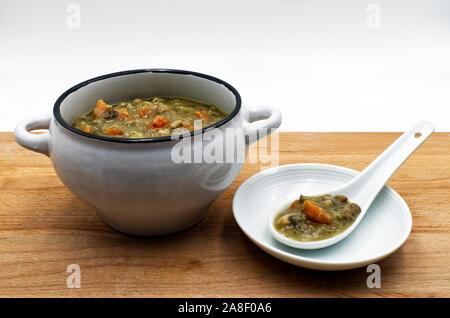 Frische toskanische Suppe, zuppa Toscana, in eine weiße Tasse mit Löffel aus Keramik Stockfoto