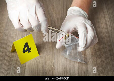 Crime Scene Investigation - Forensische officer Sammeln einer bullet Gehäuse als Beweisstück Stockfoto