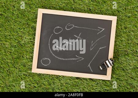 Fussball sport Schiedsrichter chrom Pfeife mit spiel strategie Zeichnung Blackboard auf Gras Hintergrund-selektiven Fokus, Ansicht von oben flach von oben Stockfoto